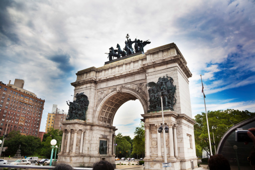 Tourists in a double decker bus passing by Soldiers' and Sailors' Memorial Arch in Brooklyn, New York.