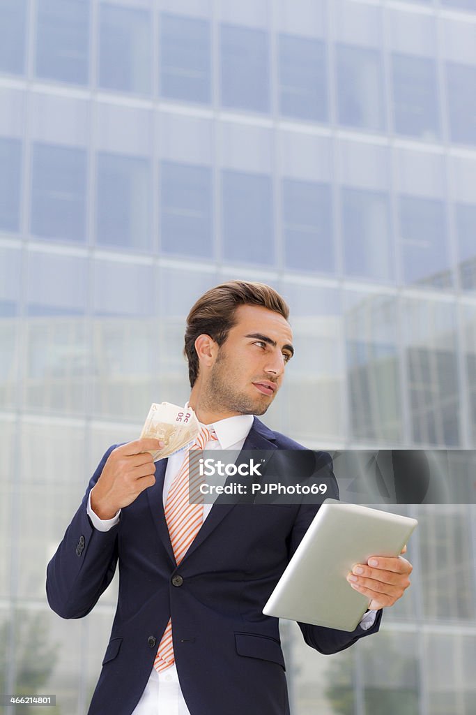 Молодой Бизнесмен за пределами офиса, держа планшета и деньги - Стоковые фото 20-29 лет роялти-фри