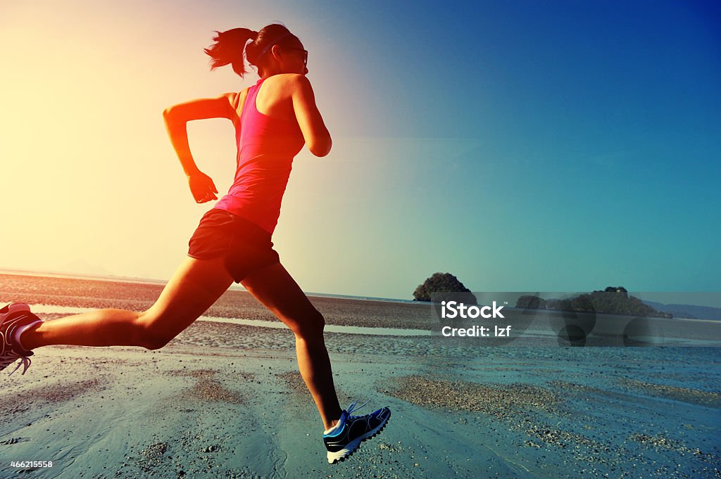 young fitness woman running on sunrise beach 2015 Stock Photo