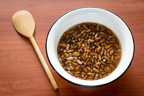 Brown Beans in Water Brown beans soaking in water before to be cooked in a pot drenched stock pictures, royalty-free photos & images