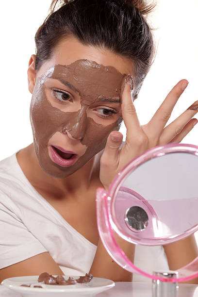 istock Young woman enjoys applying face mask 466216248