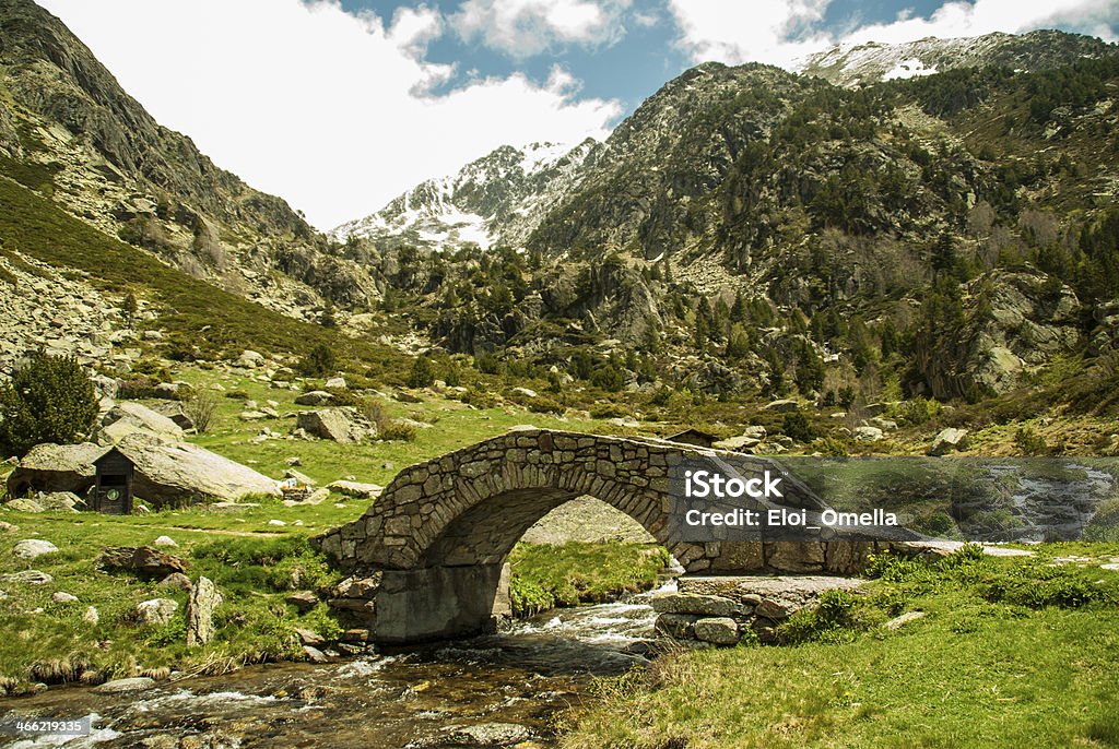 snow capped mountains with river and bridge snow capped mountains with river and a stone bridge Andorra Stock Photo