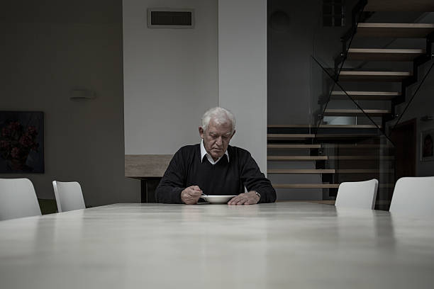 Elderly man eating dinner Elderly man eating dinner completly alone in huge house divorcee stock pictures, royalty-free photos & images