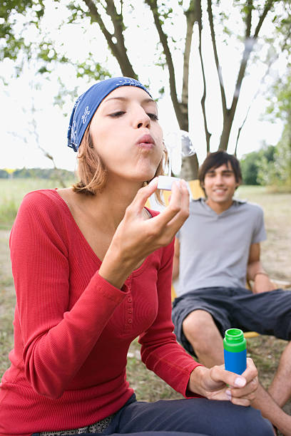 istock Young woman blowing bubbles 466221058