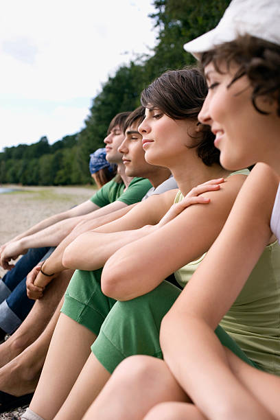 istock Friends sitting near lake relaxing 466221076