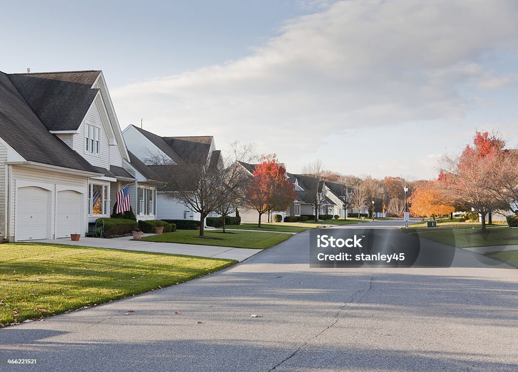 Calle suburbana con uniforme carcasa residencial - Foto de stock de Otoño libre de derechos