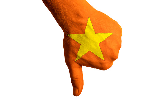 Hand with thumbs down gesture in colored vietnam national flag as symbol of negative political, cultural, social management of country