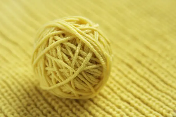 Photo of Tangle of yellow wool yarn for knitting