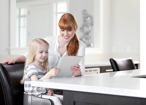 istock Mother and daughter looking at a digital tablet 466223925