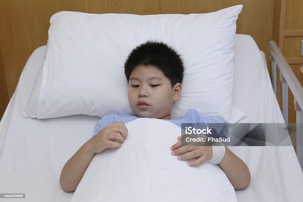 Jeune garçon Porte Maillot à l'hôpital lit de patient - Photo de Bandage libre de droits