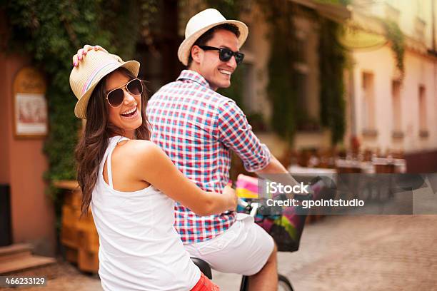 Happy Couple Riding A Bicycle In The City Street Stock Photo - Download Image Now - Activity, Adult, Adults Only