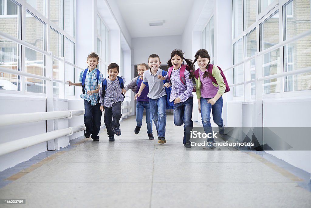 After classes happiness Happy elementary students running along school corridor Education Stock Photo
