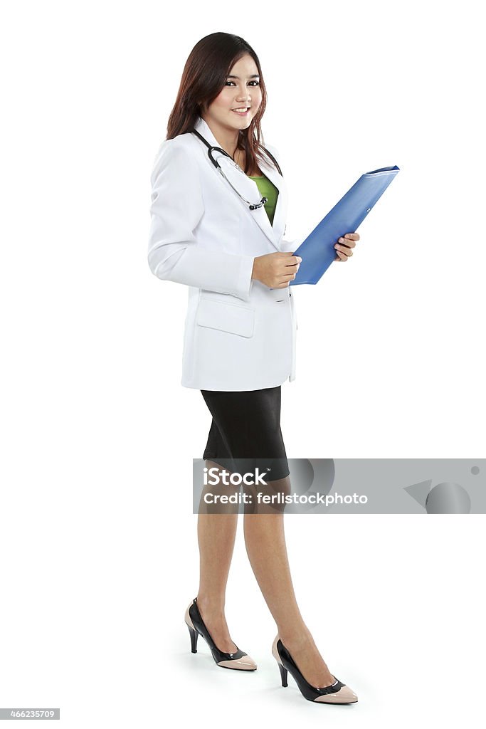 Attractive female doctor in lab coat holding clipboard Attractive female doctor in lab coat holding clipboard isolated over white background Adult Stock Photo