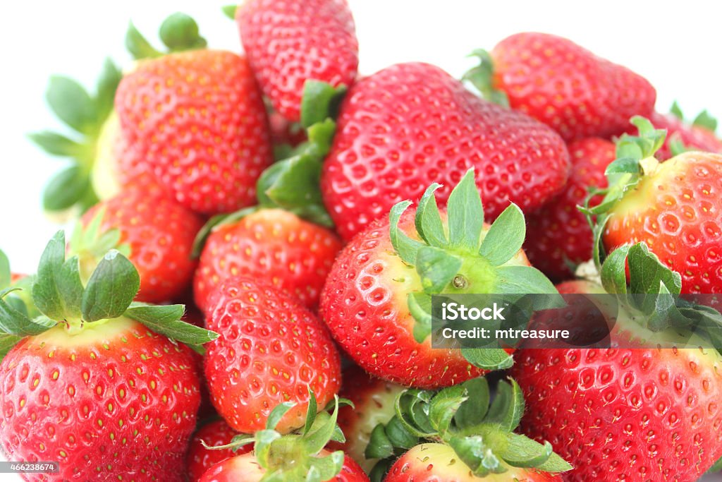 Image of fresh red strawberries, strawberry fruit with green stalks Photo showing a pile of bright red strawberries, which are homegrown and freshly picked from the garden.  The strawberry is a popular summer fruit that is considered to be an especially healthy snack 'super food', since they are packed with beneficial antioxidants and fibre, being a good source of vitamin C. 2015 Stock Photo