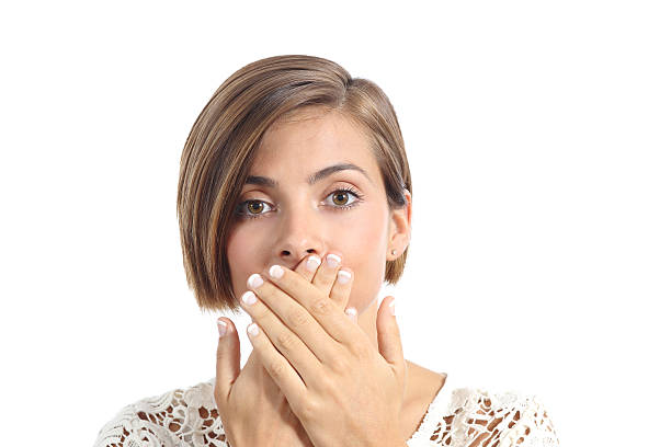 Woman covering her mouth because bad breath Woman covering her mouth because bad breath isolated on a white background bad teeth stock pictures, royalty-free photos & images