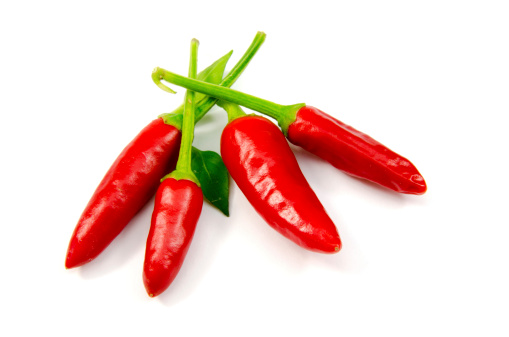 Four red chillies on white background