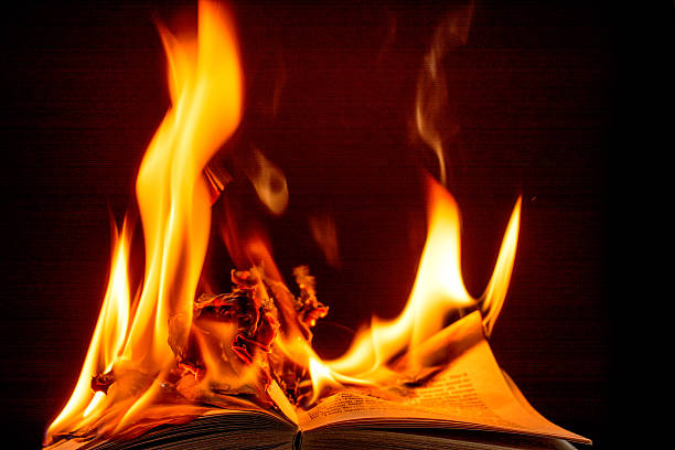 Burning book engulfed in brilliant  flames-  black background. Burning book with the word Censure- black background and close-up with brilliant flames. book burning stock pictures, royalty-free photos & images