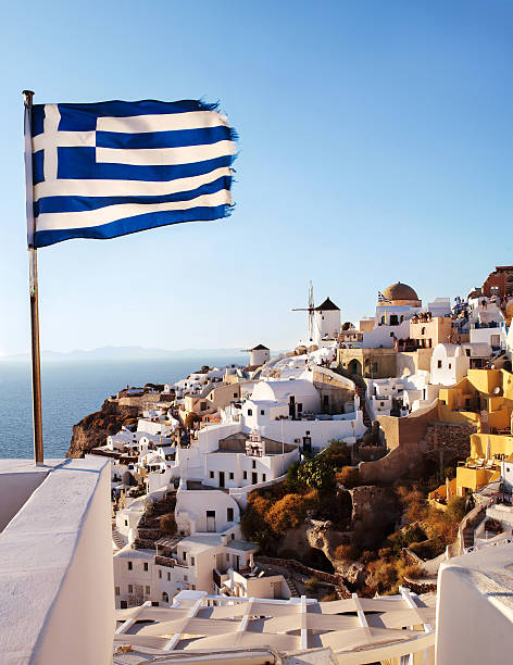 istock Oia, Santorini. Windmill on cliff side, and Greek flag. 466240544
