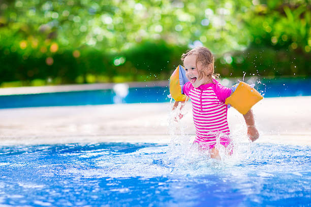 bambina giocando in piscina - inflatable ring foto e immagini stock