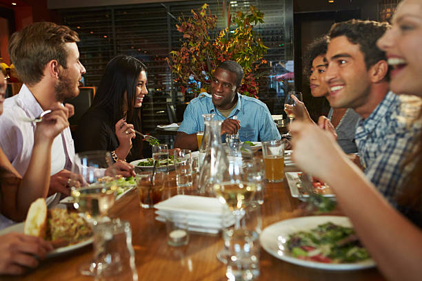 istock Group Of Friends Enjoying Meal In Restaurant 466248897