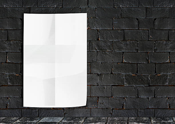 istock White Crumple Poster on grunge brick wall & footpath 466250196