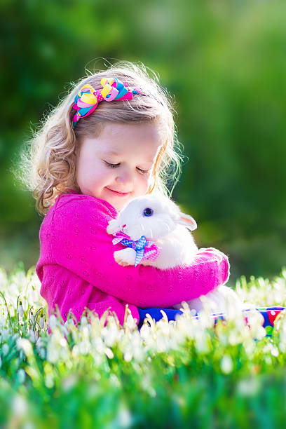 istock Beautiful little girl playing with a rabbit 466250436