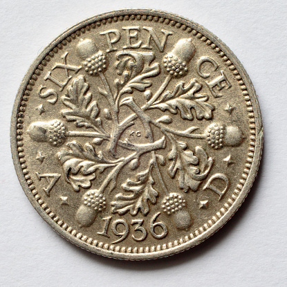 This is the back / reverse of a silver sixpence dated 1936. (Actually, by this date, British coins were only half made of silver.) This one is in very good condition, although close inspection shows up the scratches that it has accumulated during nearly 80 years. 1936 was in the reign of King George V, whose portrait adorns the obverse / front of this coin. A variety of British sixpenny pieces, sixpences, front and back: .
