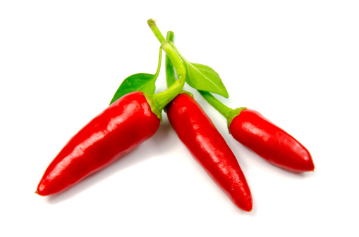 Three red chillies on white background