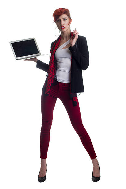 Fashionable red haired business woman holds laptop and smartphone stock photo