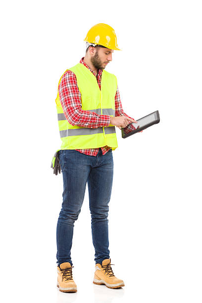 concentré travailleur à l'aide d'une tablette numérique - manual worker full length isolated on white standing photos et images de collection