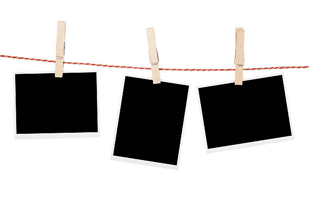 Blank photos hanging on clothesline Blank photos hanging on clothesline. Isolated on white background clothespin photos stock pictures, royalty-free photos & images