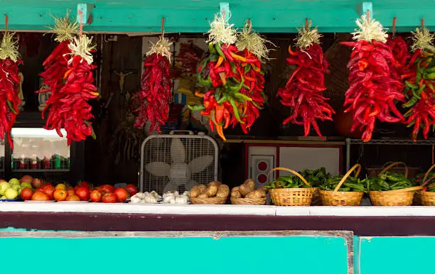 Red chili pepper ristras hung at a roadside veggie stand in New Mexico.
