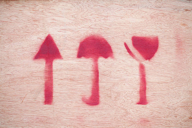 Close-up of arrow; umbrella and glass sign on wooden background.