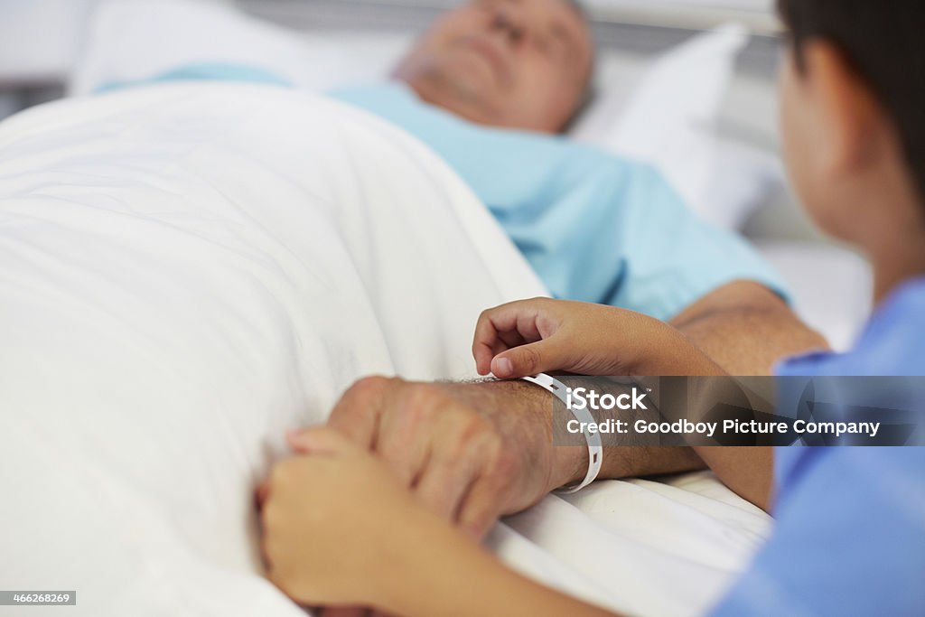 Please get better, Grandpa A young boy holding his ailing grandfather's hand in hospital Hospital Stock Photo