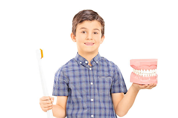 istock Little boy holding denture and a toothbrush 466269430