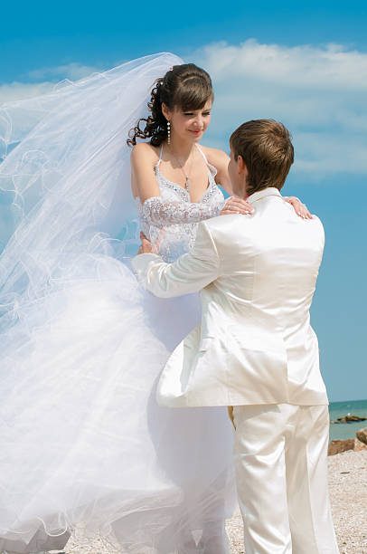 istock Young and beautiful bride and groom on the beach 466270018