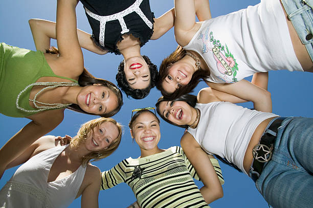 istock Cheerful Friends Forming Huddle Against Blue Sky 466274651