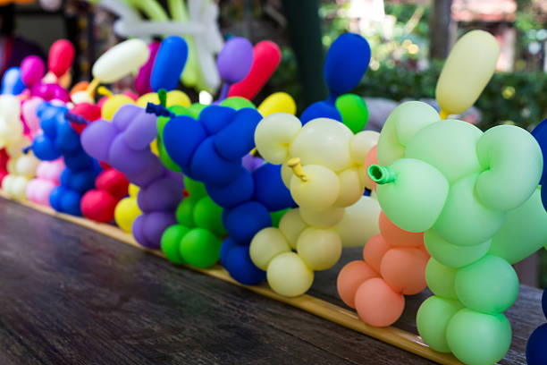 Balloon animal many stand in a line on the table.