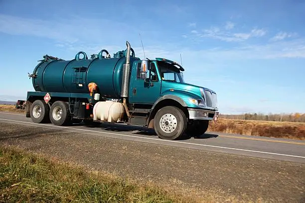 Tanker truck being driven on highway. Selective focus on truck.