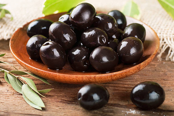 istock Black olives in a wooden plate 466281497