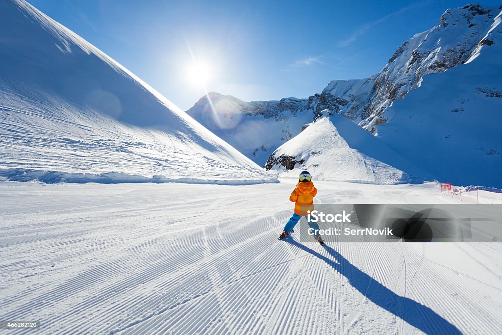 Boy on ski-track skiing view from back in Sochi Boy on ski-track skiing view from back on Sochi ski resort Krasnaya polyana in Russia Child Stock Photo