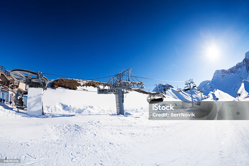 Ski resort panorama with piste and skilift ropeway Panorama of chair lift ropeway and piste on ski winter resort on sunny day  2015 Stock Photo