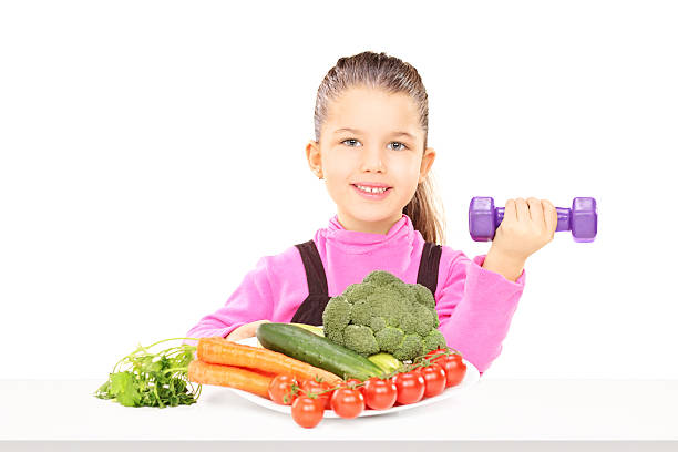 istock Cute child sitting at table with plate of vegetables 466282309