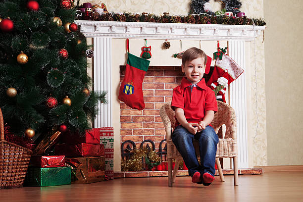 Feliz rapaz na frente da Árvore de Natal de espera - fotografia de stock