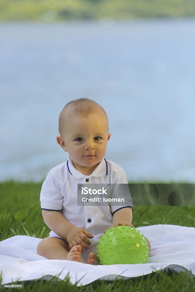 European bambino seduto sull'erba - 10 mesi di età - Foto stock royalty-free di 0-11 Mesi