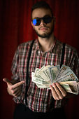 junger-mann-posieren-mit-usa-dollar.jpg?b=1&s=170x170&k=20&c=uzxBQeDFYvKErobHGPyLH1OF7xJSz6IhOYKDL2b0hPM=