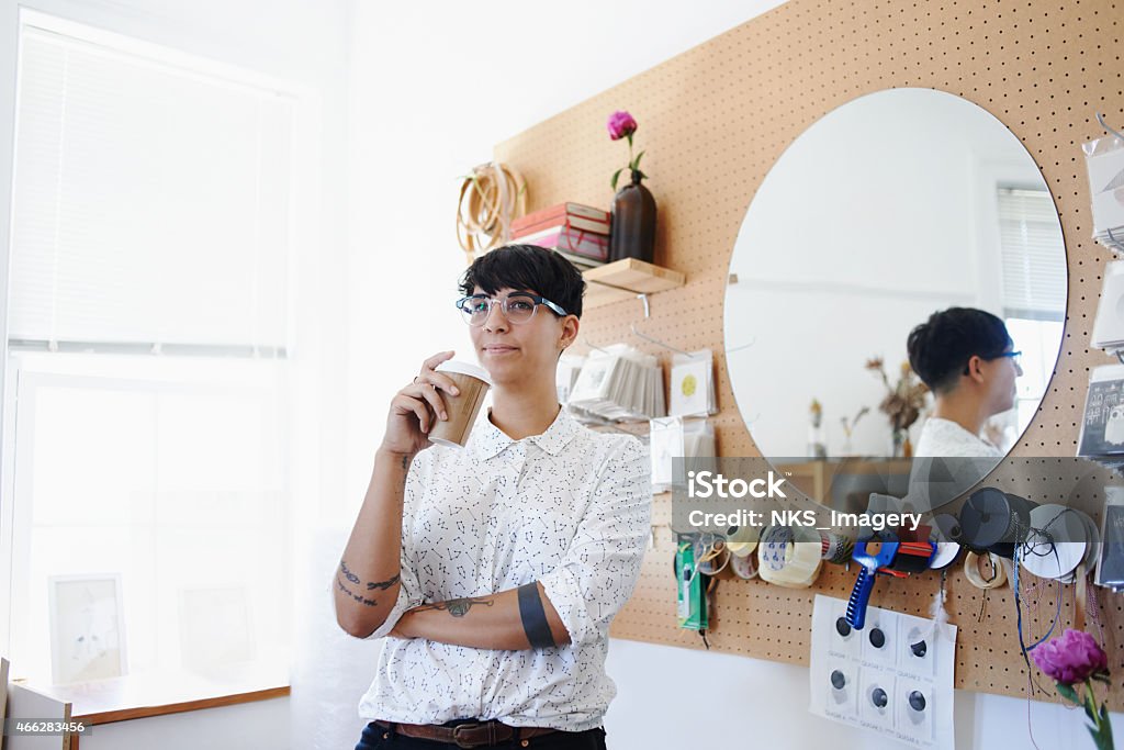 Considering her next project Shot of a young designer standing in her home studio drinking a coffeehttp://195.154.178.81/DATA/i_collage/pu/shoots/785142.jpg 20-29 Years Stock Photo