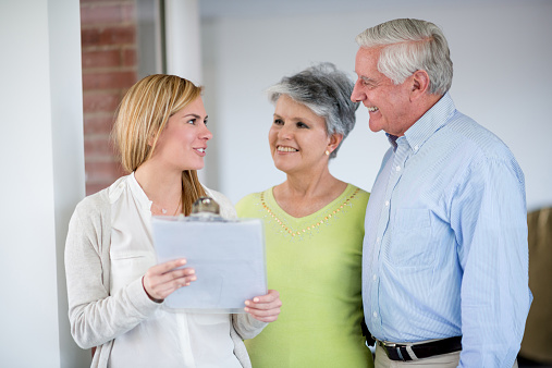 Real estate agent showing house to senior couple