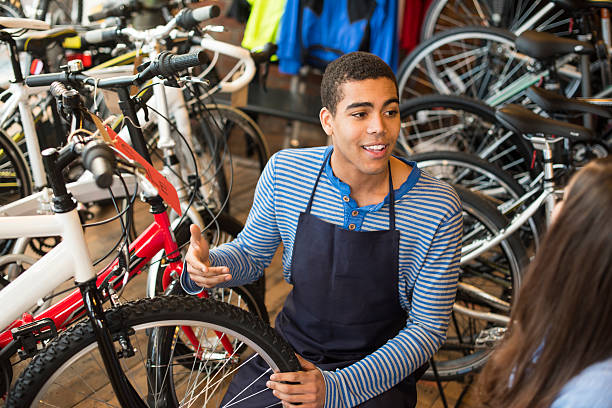 young bike shop worker talks to a customer