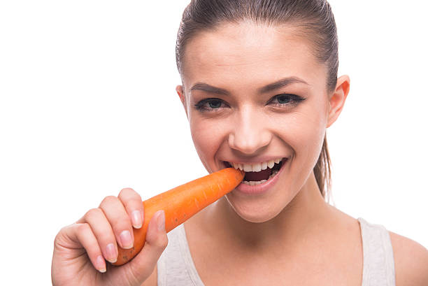 istock Young healthy woman snacking on a carrot 466284728
